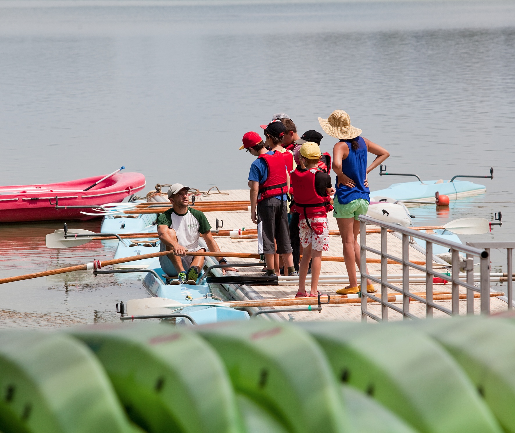 Un moniteur est en train d'apprendre à des enfants à comment tenir sur un kayak et comment sa marche