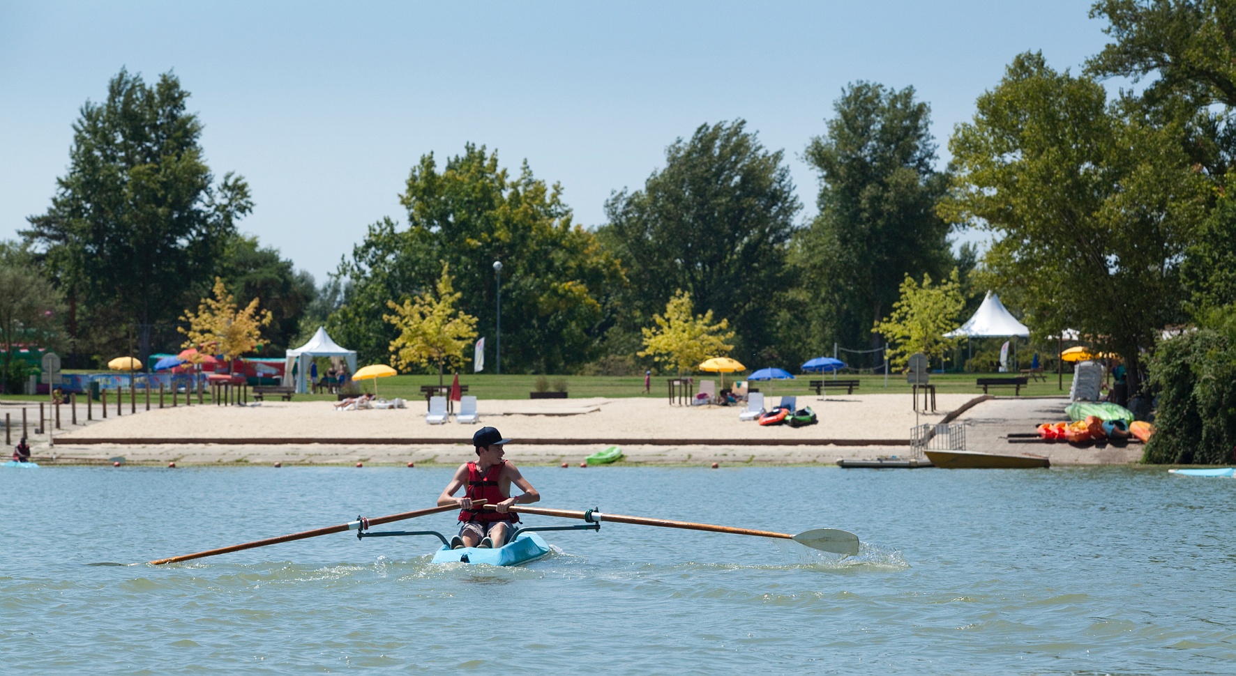Un jeune garçon en train de faire du kayak sur le plan d'eau de la base de loisirs