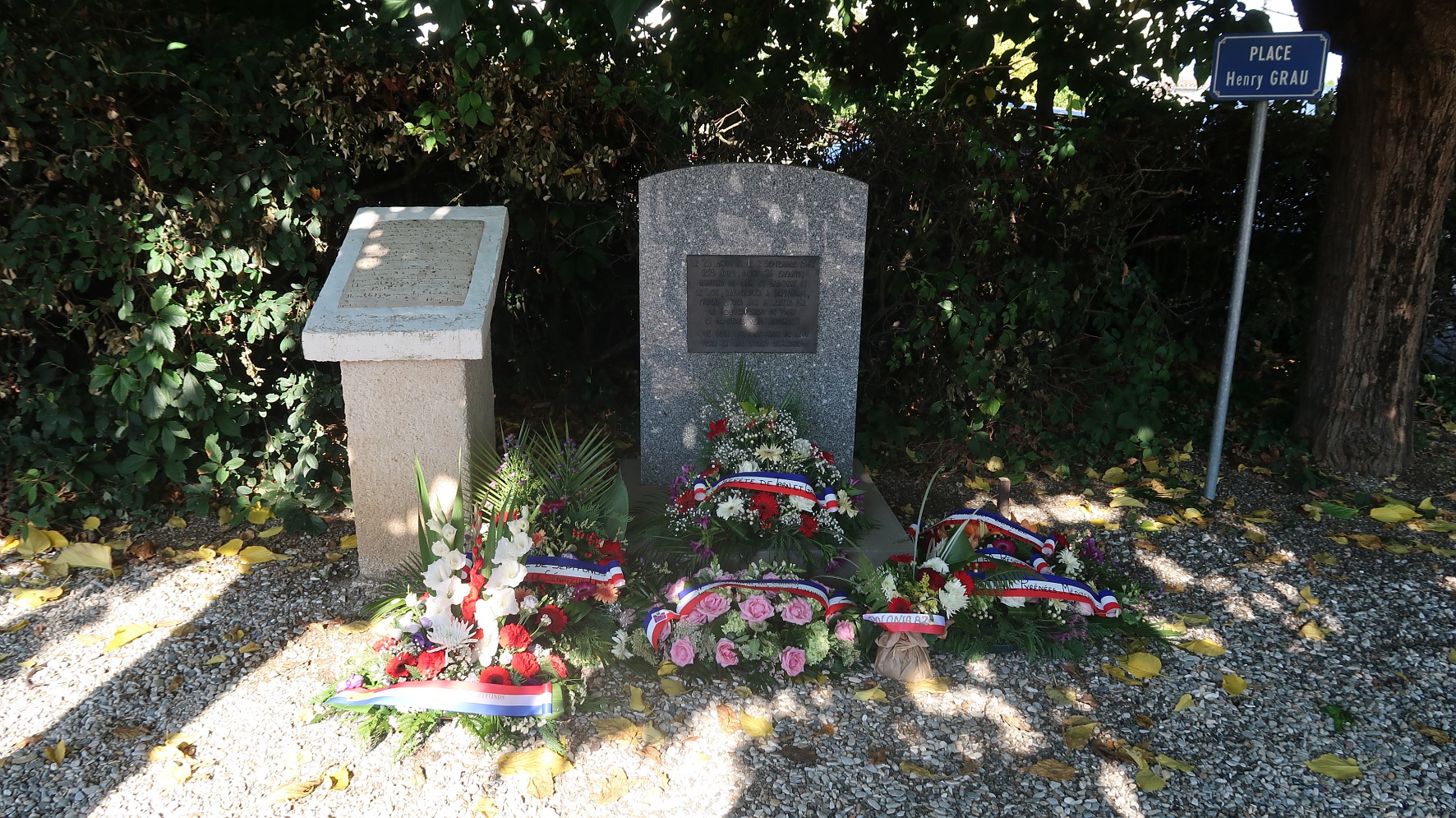 Photo d'un monument aux morts avec des gerbes devant à Septfonds 