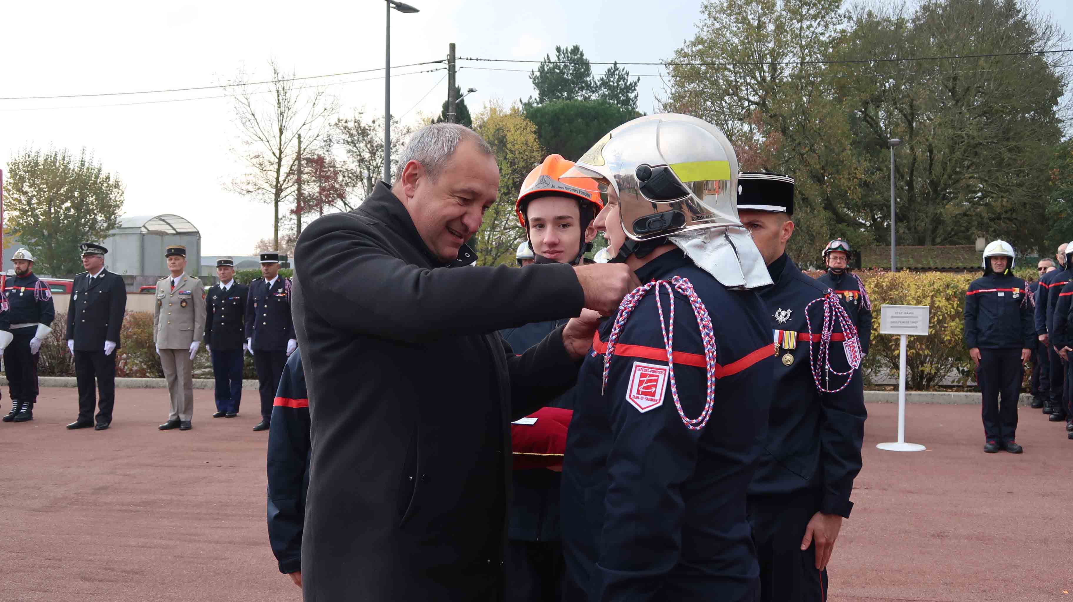 Emmanuel Cros qui remet une médaille à un pompier 