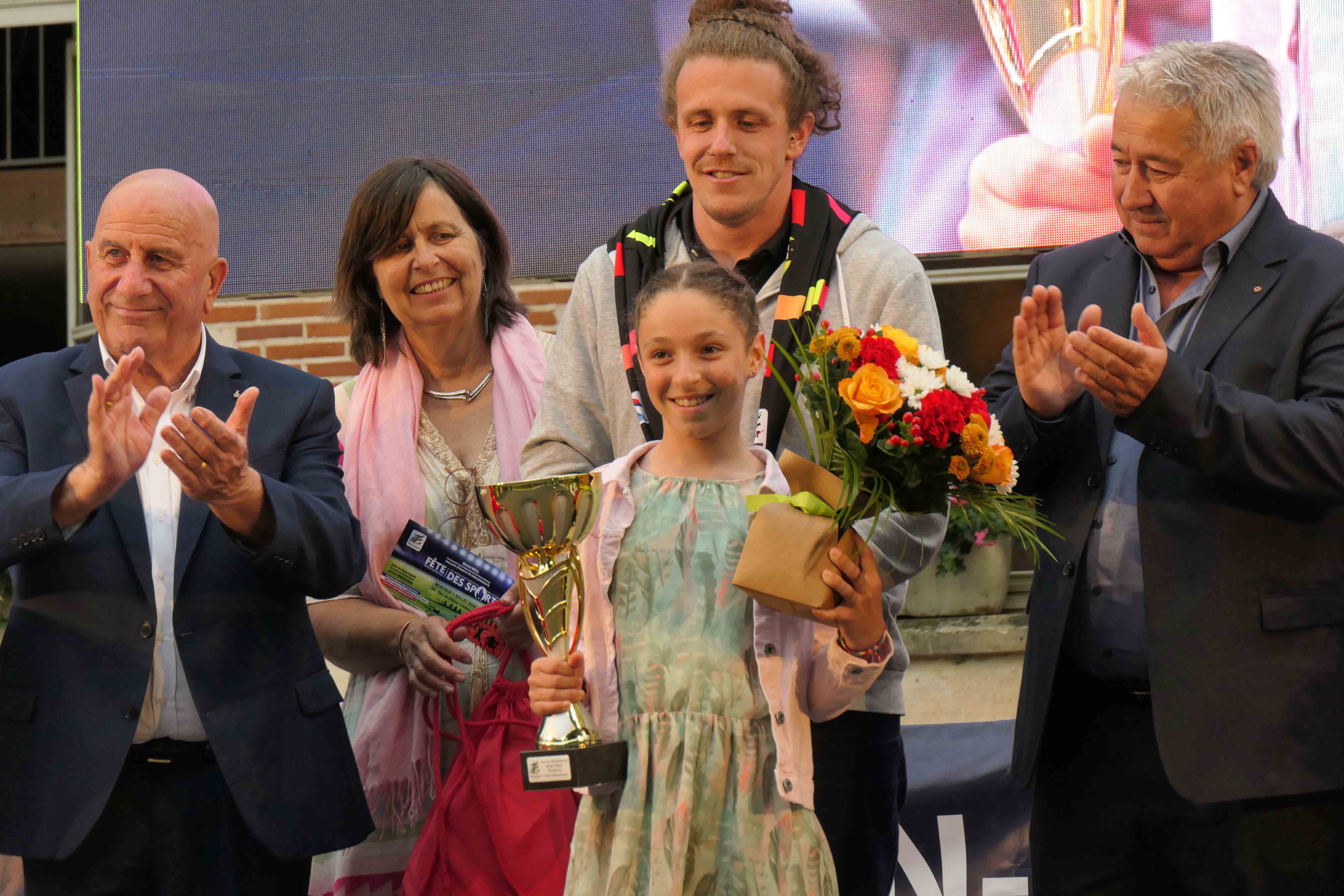 Deux sportifs ( fille et coach) recevant un prix de la part des élus