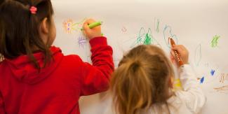 Deux petites filles en train de faire du coloriage 