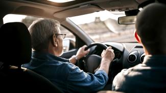 CAR 82 Un sénior en train de conduire avec un moniteur d'auto-école