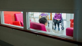 Aide à l'hébergement séniors Un groupe de personnes assises ensemble dans une pièce bien éclairée, engagées dans une discussion