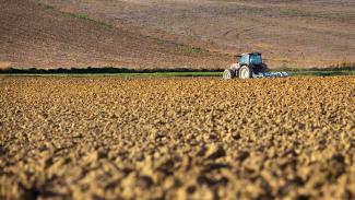 Nous pouvons voir un tracteur entrain de récolter du blé 