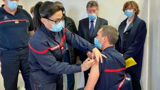 vaccination pompier Nous pouvons voir une pompier en train de vacciné un autre pompier pour le covid