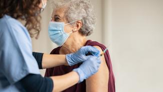 Vaccination covid 19 une infermiere en train de vacciné une personne agée pour le covid 19