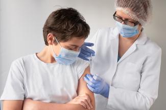 Istock vaccin jeune On peut voir une infermière entrain de vacciner un jeune