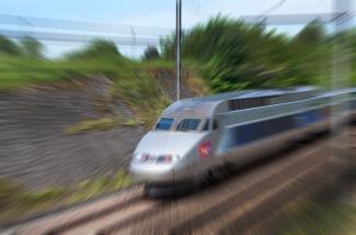 LGV On peut voir un train aller a grande vitesse sur des rails de chemin de fer