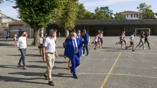 président Weill On peut voir le Président Weill danas une cours de récréation avec des enfants autour