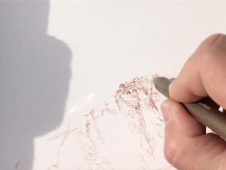 Une main en train de dessiner sur une feuille 