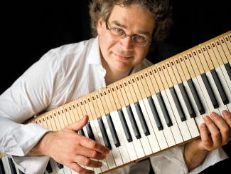 Concert de musique classique "Looking for Beethoven" au théâtre Olympe de Gouges Pascal Amoyel avec un piano électrique dans les mains qui le tient comme une guitare