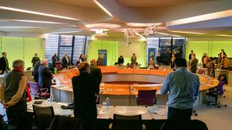 Réunion dans la salle plénière Les élus debout devant leur chaises lors d'une réunion en salle plénière