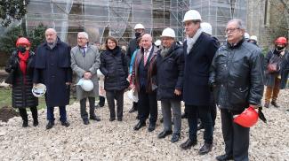 Michel Weill, les élus et d'autres personnalités en train de visiter l'extérieur du chantier de l'abbaye de Beaulieu-en-Rouergue