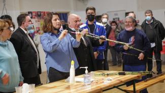 La ministre des sports Roxana Maracineanu et Michel Weill en train d'essayer un handisport, et qui soufflent dans un long tube 
