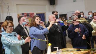 La ministre des sports Roxana Maracineanu et Michel Weill en train d'essayer un handisport, et qui soufflent dans un long tube 