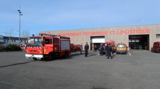 Le Département fait le don d’un Fourgon Pompe Tonne Léger aux pompiers ukrainiens Bâtiment du groupement technique et logistique du SDIS 82 avec plusieurs véhicules positionnés devant et la présence de sapeurs-pompiers, d'élus et du président