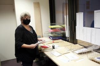 Sylvie, la responsable du service, sourit sous son masque