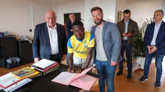 Sékouna Camara signe pour le club de Sochaux Sékouna Camara en train de signer son contrat en présence de Michel Weill et d'un représentant du club