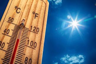 Visuel : Canicule Un thermomètre affichant 40*C avec un ciel bleu et le soleil