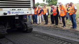 Visite d'un chantier expérimental à Génébrières Michel Weill, des élus et les représentants des entreprises en train de regarder les engins en action
