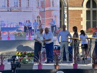 Michel Weill, sur scène, qui remet une coupe à un lauréat en compagnie de Bernard Pécou et Dominique Sardeing 