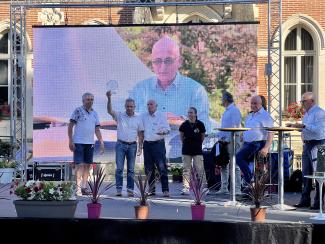 Les lauréats sur scène qui lèvent leur prix en compagnie du président et de nombreux élus 