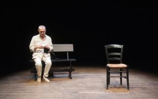 Pièce de théâtre "Alphonse, une histoire d'amour" à l'espace des Augustins Un homme assis sur un banc en train de tricoter