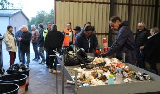 Sensibilisation des élus à la gestion et le tri des déchets à la déchetterie de Nègrepelisse. Plusieurs élus qui discutent et certains qui trient un tas de déchets