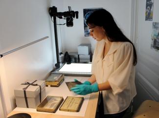 Camille manipule avec précaution un négatif sur plaque de verre au gélatinobromure d’argent, 1890-1900, 13x18cm.