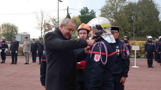 Emmanuel Cros qui remet une médaille à un pompier 