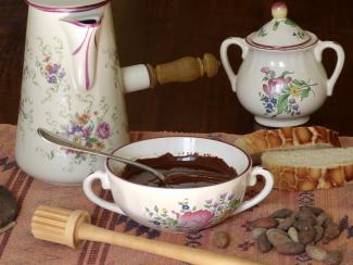 Conférence dégustation sur les boissons exotiques à l'abbaye de Belleperche Photo de vaisselles ancienne avec un bol remplit de chocolat fondu, du pain et des cailloux sur une table
