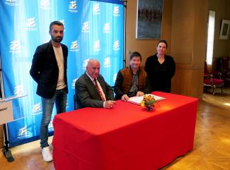 Signature du contrat d'équipement pour 6 communes Michel Weill assis à table entouré d'élus et représentants des communes pour la signature des contrats d'équipement