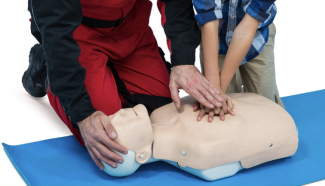 Formation des élèves à la prévention et aux secours civiques Deux personnes qui pratiquent des gestes de premier secours sur un mannequin