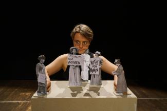 Scène de théâtre "En avant toutes" à l'espace des Augustins Une femme qui anime une scène de théâtre papier avec 5 femmes en papiers qui défendent leurs droits
