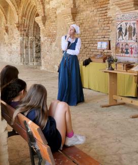 une actrice en costume médiéval devant son public