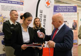 Cérémonie de récompense à la Croix-Rouge Michel Weill remettant un prix à une jeune fille lors de la cérémonie de récompense à la Croix-Rouge