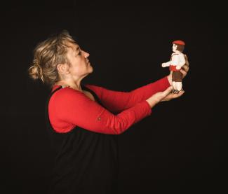 Spectacle de marionnettes :"Au pays des Laminaks" à l'abbaye de Belleperche Une femme de profil qui tient une marionnette dans ses mains en face d'elle