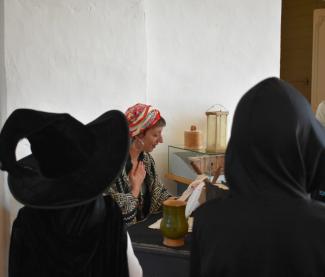 Photo d'une dame en train de lire un papier à des enfants 