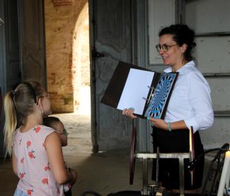 Une femme qui montre la page d'une livre à une jeune fille 