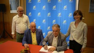 Signature du contrat d'équipement pour le village de Meauzac Des élus assis à table qui signent un contrat