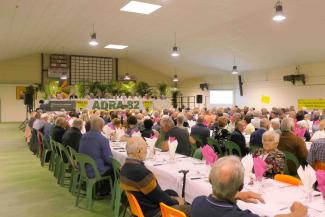 Photo de l'assemblée générale de l'ADRA 82 en juin 2024 Plusieurs personnes assises à table dans une salle des fêtes