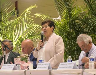 Photo de l'assemblée générale de l'ADRA 82 en juin 2024 Une femme en train de parler au micro debout derrière une table