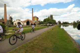 Arrivée de la flamme olympique au département par les collégiens J.O Paris 2024 Plusieurs collégiens en train de faire du vélo le bord du canal