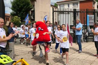 Arrivée de la flamme olympique au département par les collégiens J.O Paris 2024 Plusieurs collégiens en train de courir vers l'hôtel du département avec des leur bras la mascotte peluche des J.O 2024