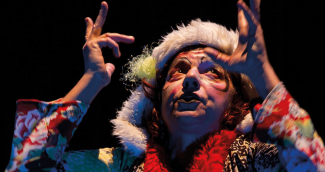 Comédie tragique "Olga" jouée par Nathalie Vinot à l'espace des Augustins Une personne maquillée en clown regarde en l'air avec les mains en l'air.
