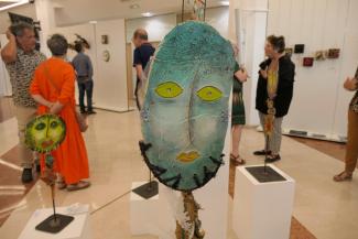 Sculpture abstraite d'un visage en long bleu avec des yeux et une bouche verdâtres 