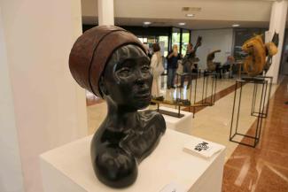 Sculpture d'un buste de couleur sombre d'une femme portant un couvre-chef 