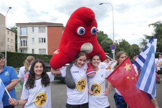 Arrivée de la flamme olympique au département par les collégiens J.O Paris 2024 Des collégiennes portant sur leur épaule la peluche mascotte des J.O 2024 avec également le drapeau de la Chine et de la Grèce