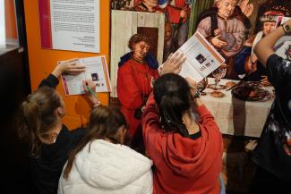Adolescentes complétant un livret d'activité sur l'Abbaye de Belleperche Trois adolescentes complétant un livret contre un mur